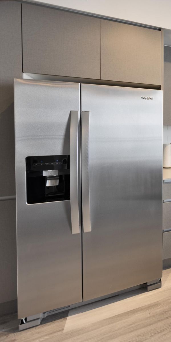 The Upland Modern kitchen with stainless steel appliances, table set for two, and large window with blinds.
